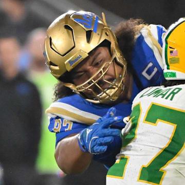 Sep 28, 2024; Pasadena, California, USA; UCLA Bruins defensive lineman Jay Toia (93) tackles Oregon Ducks running back Jayden Limar (27) during the fourth quarter at Rose Bowl. Mandatory Credit: Robert Hanashiro-Imagn Images