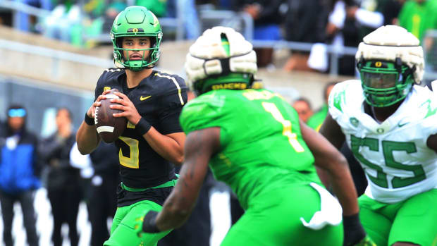 Oregon White Team quarterback Dante Moore, left, drops back to pass during the second quarter of the Spring Game.