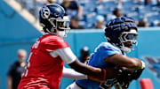 Tennessee Titans quarterback Cam Ward (1) hands the ball off to running back Kalel Mullings (28) during “Back Together Weekend” training camp practice at Nissan Stadium Saturday, July 26, 2025, in Nashville, Tenn.