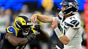Nov 16, 2025; Inglewood, California, USA; Seattle Seahawks quarterback Sam Darnold (14) is pressured by Los Angeles Rams linebacker Byron Young (0) at SoFi Stadium. 