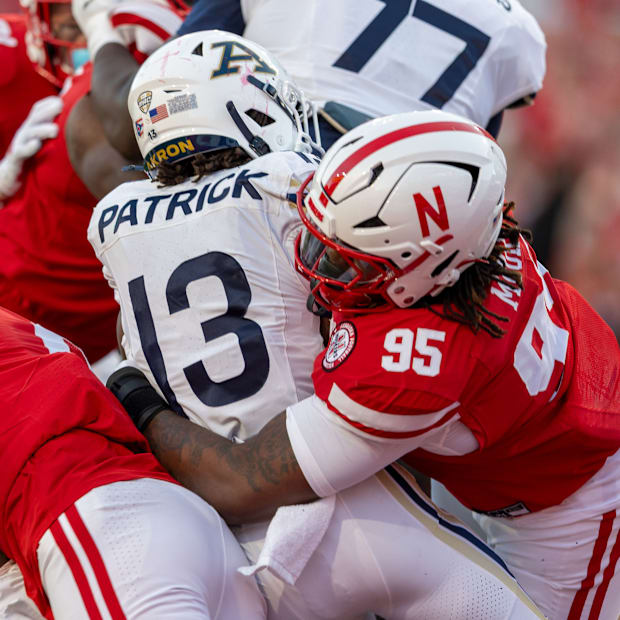 Nebraska defensive lineman Gabe Moore combines with Javin Wright to bring down Akron's Sean Patrick.