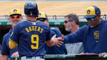 Aug 24, 2024; Oakland, California, USA; Milwaukee Brewers infielder Jake Bauers (9) shakes hands with a coach after scoring a run against the Oakland Athletics during the second inning at Oakland-Alameda County Coliseum. Mandatory Credit: Robert Edwards-USA TODAY Sports