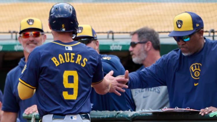 Aug 24, 2024; Oakland, California, USA; Milwaukee Brewers infielder Jake Bauers (9) shakes hands with a coach after scoring a run against the Oakland Athletics during the second inning at Oakland-Alameda County Coliseum. Mandatory Credit: Robert Edwards-USA TODAY Sports