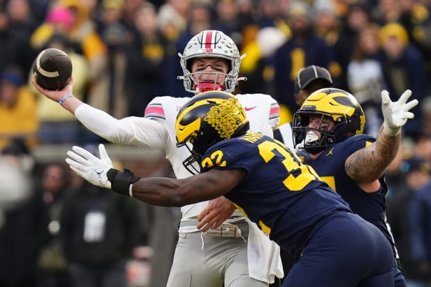 Michigan defensive end Jaylen Harrell pressures Ohio State quarterback Kyle McCord, forcing game-winning interception