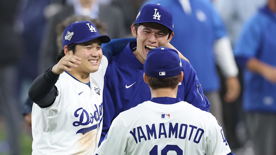 Los Angeles Dodgers designated hitter Shohei Ohtani celebrates with pitcher Roki Sasaki  and pitcher Yoshinobu Yamamoto
