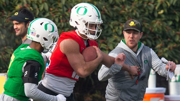 Oregon offensive coordinator and quarterbacks coach Will Stein, right, participates in a drill with defensive back Steve Step