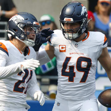 Sep 8, 2024; Seattle, Washington, USA; Denver Broncos linebacker Alex Singleton (49) celebrates with cornerback Riley Moss (21), safety P.J. Locke (6) and cornerback Ja'Quan McMillian (29) after intercepting a pass against the Seattle Seahawks during the first quarter at Lumen Field. 