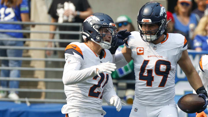 Sep 8, 2024; Seattle, Washington, USA; Denver Broncos linebacker Alex Singleton (49) celebrates with cornerback Riley Moss (21), safety P.J. Locke (6) and cornerback Ja'Quan McMillian (29) after intercepting a pass against the Seattle Seahawks during the first quarter at Lumen Field. 