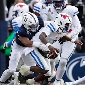 Dec 21, 2024; University Park, Pennsylvania, USA; Southern Methodist Mustangs quarterback Kevin Jennings (7) is sacked by Penn State Nittany Lions defensive end Abdul Carter (11) during the third quarter in the first round of the College Football Playoff at Beaver Stadium.  