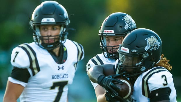 Buchholz Bobcats quarterback Trace Johnson (12) hands off to Buchholz Bobcats running back Jasiah Powell (3) in the first hal