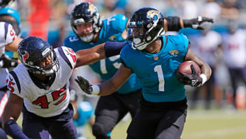 Jaguars running back Travis Etienne Jr. (1) is pressured by Houston Texans linebacker Ogbonnia Okoronkwo (45), Sunday, Oct. 9, 2022, in Jacksonville.