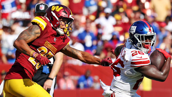 Sep 15, 2024; Landover, Maryland, USA; New York Giants cornerback Cor'Dale Flott (28) runs the ball against Washington Commanders cornerback Benjamin St-Juste (25) during the fourth quarter at Commanders Field. Mandatory Credit: Peter Casey-Imagn Images