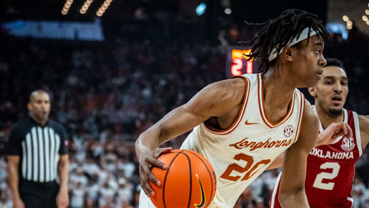 Texas Longhorns guard Tre Johnson (20) drives past defense from Oklahoma Sooners guard Brycen Goodine (2) in the first half of the Longhorns' game against the Sooners.