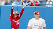 Oklahoma outfielder Jayda Coleman (24) celebrates a single next to Texas' Katie Stewart (20) in the first inning during Game 2 of the NCAA softball Women's College World Series Championship Series game between the Oklahoma Sooners (OU) and Texas Longhorns at Devon Park in Oklahoma City, Thursday, June, 6, 2024.