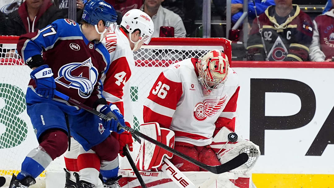 Feb 2, 2026; Denver, Colorado, USA; Detroit Red Wings goaltender John Gibson (36) makes a save next to defenseman Axel Sandin-Pellikka (44) and Colorado Avalanche center Parker Kelly (17) in the first period at Ball Arena. Mandatory Credit: Ron Chenoy-Imagn Images