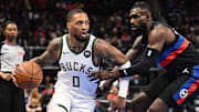 Dec 3, 2024; Detroit, Michigan, USA;  Milwaukee Bucks guard Damian Lillard (0) controls the ball against Detroit Pistons forward Tim Hardaway Jr. (8) in the first quarter at Little Caesars Arena. Mandatory Credit: Lon Horwedel-Imagn Images