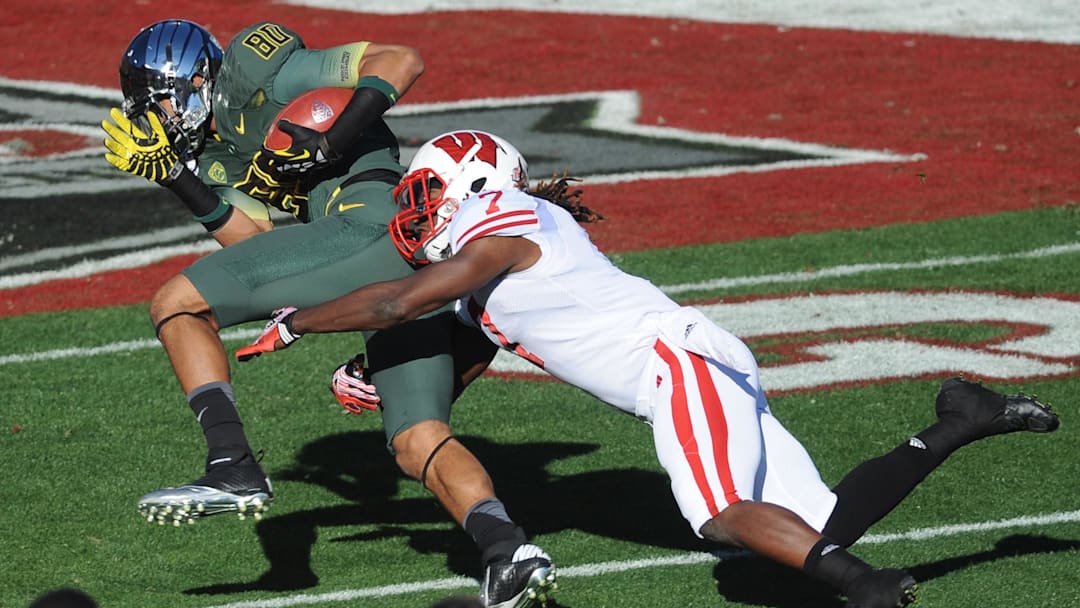 Jan 2, 2012; Pasadena, CA, USA; Oregon Ducks wide receiver Lavasier Tuinei (80) catches a pass and is tackled by Wisconsin Badgers safety Aaron Henry (7) in the 2012 Rose Bowl game at the Rose Bowl. Mandatory Credit: Kelvin Kuo-Imagn Images
