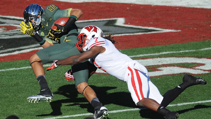 Jan 2, 2012; Pasadena, CA, USA; Oregon Ducks wide receiver Lavasier Tuinei (80) catches a pass and is tackled by Wisconsin Badgers safety Aaron Henry (7) in the 2012 Rose Bowl game at the Rose Bowl. Mandatory Credit: Kelvin Kuo-Imagn Images
