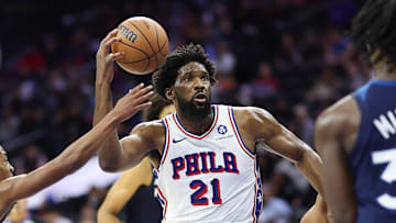Oct 17, 2025; Philadelphia, Pennsylvania, USA; Philadelphia 76ers center Joel Embiid (21) drives the lane between Minnesota Timberwolves guard Rob Dillingham (4) and forward Leonard Miller (33) during the third quarter at Xfinity Mobile Arena. Mandatory Credit: Bill Streicher-Imagn Images