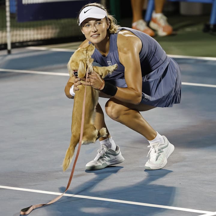 Anna Kalinskaya gretts her dog Bella on the court at the Mubadala City DC Open. 