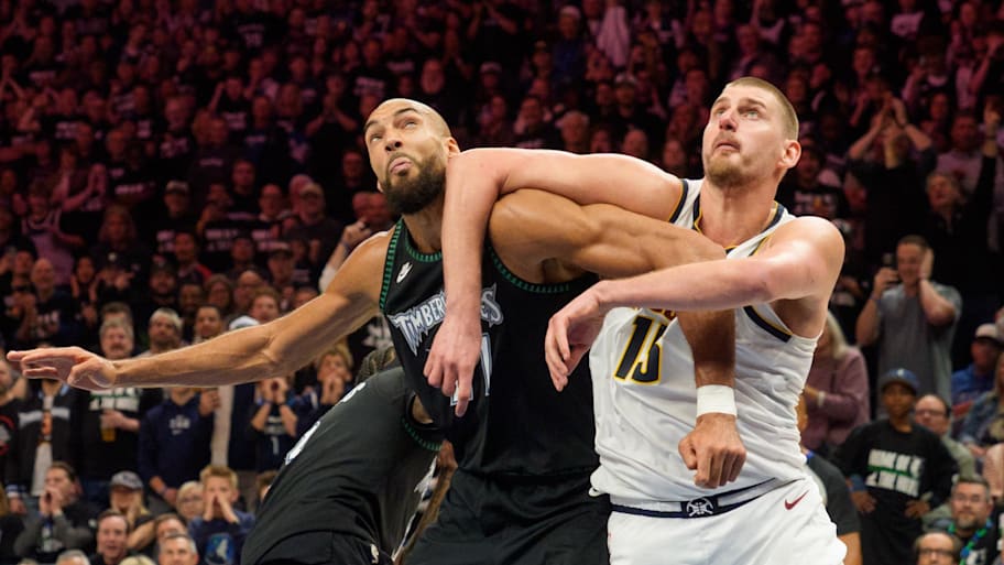 Minnesota Timberwolves center Rudy Gobert and Denver Nuggets center Nikola Jokić position themselves for a rebound.