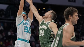 Feb 5, 2025; Charlotte, North Carolina, USA; Charlotte Hornets guard Seth Curry (30) shoots defended by Milwaukee Bucks guard Pat Connaughton (24) during the second half at Spectrum Center. Mandatory Credit: Jim Dedmon-Imagn Images
