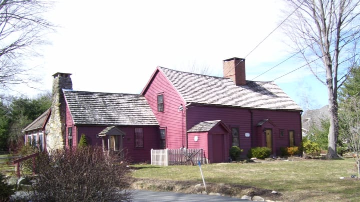 A red house with a chimney extending down one side.