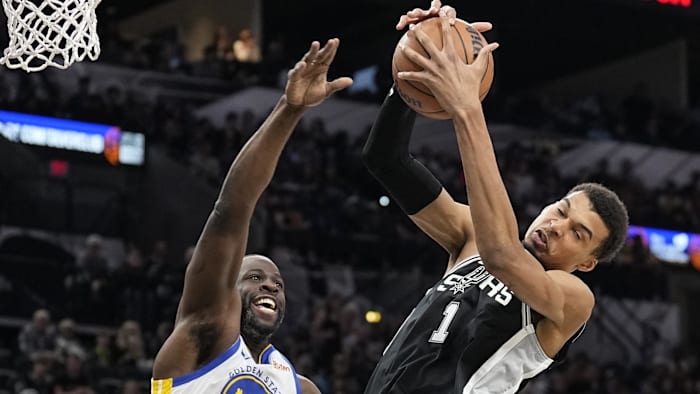 Mar 11, 2024; San Antonio, Texas, USA; San Antonio Spurs forward Victor Wembanyama (1) grabs a rebound over Golden State Warriors forward Draymond Green (23).