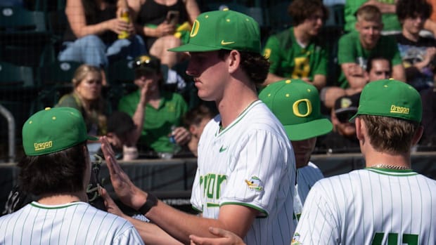 Oregon teammates congratulate pitcher Jason Reitz as he leaves the game against Michigan.
