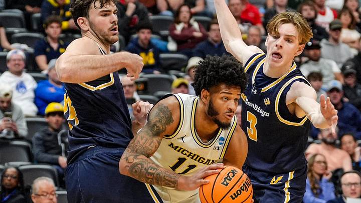 Michigan Wolverines guard Roddy Gayle Jr. (11) spilts the defense of UC San Diego Tritons forward Nordin Kapic (24) and guard Hayden Gray (3) during the second period of the first round of the NCAA tournament at Ball Arena in Denver, Colorado for .