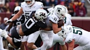 Nov 1, 2025; Minneapolis, Minnesota, USA; Minnesota Golden Gophers defensive lineman Anthony Smith (0) tackles Michigan State Spartans quarterback Alessio Milivojevic (11) during the first half at Huntington Bank Stadium. Mandatory Credit: Matt Krohn-Imagn Images