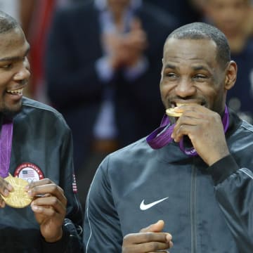 Aug 11, 2012; London, United Kingdom; USA forward Kevin Durant watches USA forward LeBron James bite the gold medal after winning the gold in the men's basketball final against Spain in the London 2012 Olympic Games at North Greenwich Arena. Mandatory Credit: Bob Donnan-USA TODAY Sports