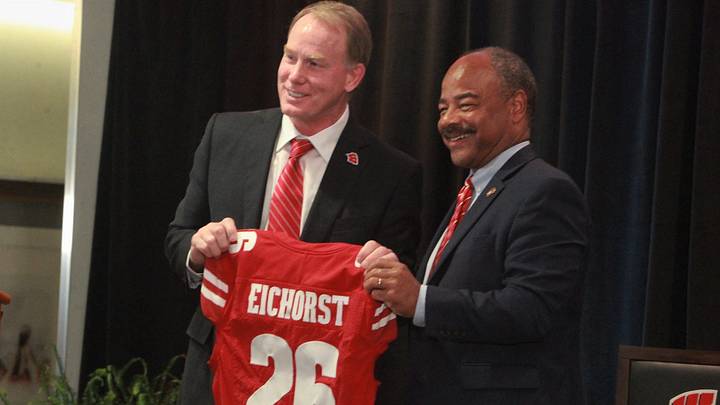 University of Wisconsin athletic director Shawn Eichorst (left) and interim chancellor Eric Wilcots pose with a Badgers football jersey during a meet-and-greet event for Eichorst at the Champions Club inside Camp Randall Stadium in Madison, Wisconsin on Tuesday July 7, 2026.