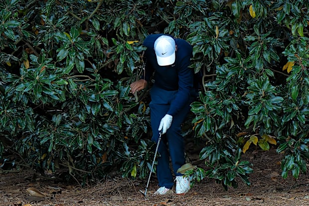 Scottie Scheffler emerges from the tree after hitting his shot on the 18th hole.