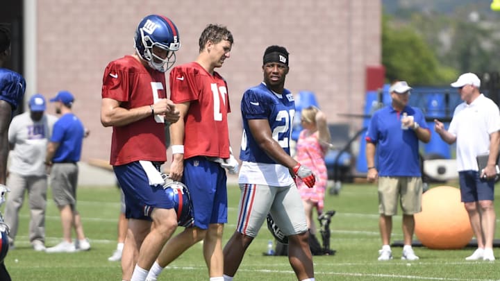 New York Giants quarterback Eli Manning (10) and rookie running back Saquon Barkley (26) talk on the field  during training camp.  