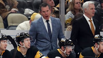 Nov 30, 2024; Pittsburgh, Pennsylvania, USA;  Pittsburgh Penguins head coach Mike Sullivan (rear) reacts on the bench against the Calgary Flames during the third period at PPG Paints Arena. Mandatory Credit: Charles LeClaire-Imagn Images