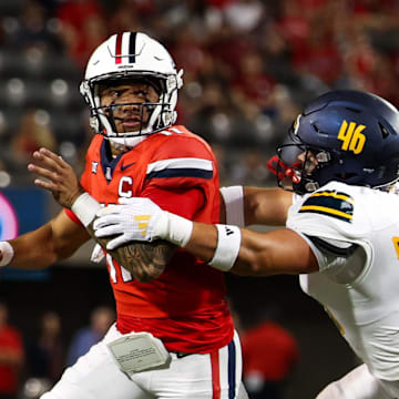 Sep 7, 2024; Tucson, Arizona, USA; Arizona Wildcats quarterback Noah Fifita (11) rolls out to pass against Northern Arizona Lumberjacks linebacker Tommy Ellis (46) during first quarter at Arizona Stadium. Mandatory Credit: Aryanna Frank-Imagn Images