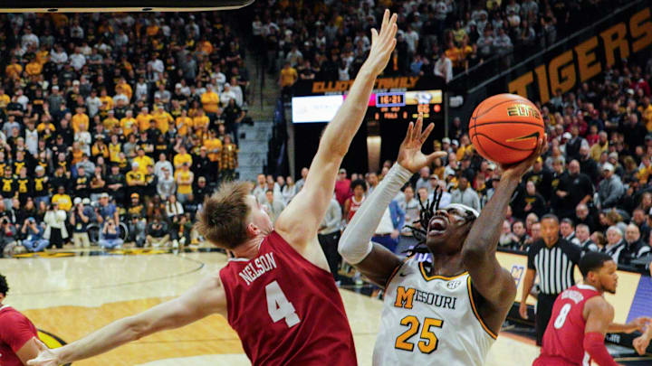 Feb 19, 2025; Columbia, Missouri, USA; Missouri Tigers guard Mark Mitchell (25) shoots as Alabama Crimson Tide forward Grant Nelson (4) defends during the second half at Mizzou Arena. Mandatory Credit: Denny Medley-Imagn Images