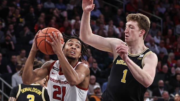 Razorbacks guard D.J. Wagner (21) looks to shoot against Michigan 7-foot forward Danny Wolf (1) in the fi