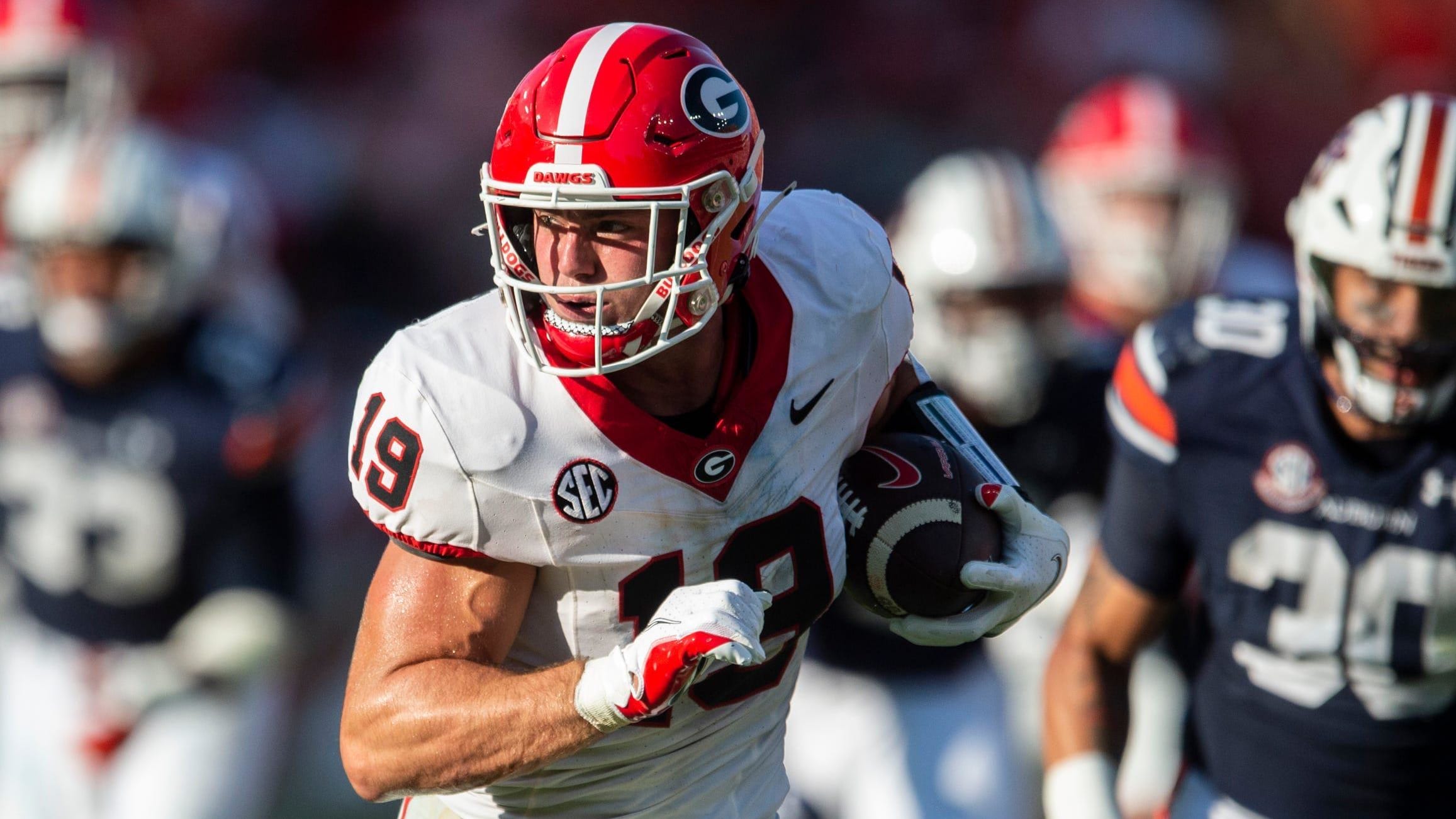 Georgia Bulldogs tight end Brock Bowers (19) runs after a catch during the third quarter as Auburn defenders pursue him.