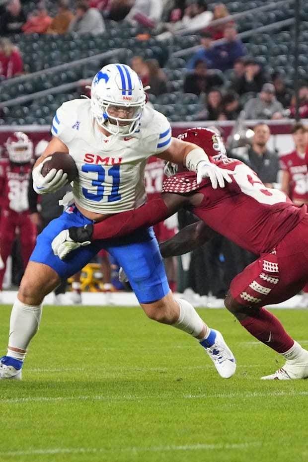 SMU Mustangs running back Tyler Lavine runs with the ball against Temple Owls linebacker Jordan Magee SMU Mustangs running back Tyler Lavine runs with the ball against Temple Owls linebacker Jordan Magee