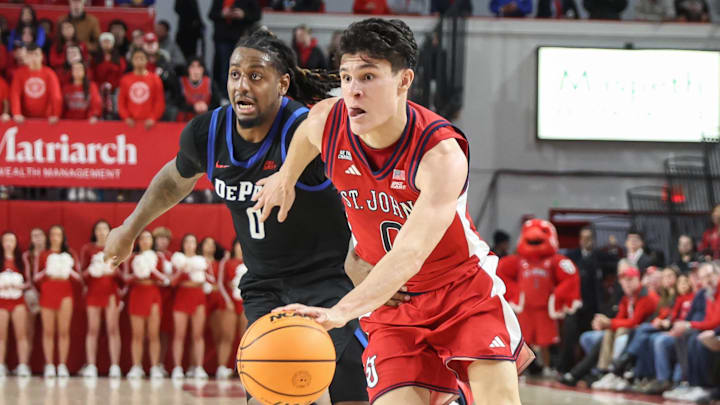 Dec 16, 2025; Queens, New York, USA; St. John's basketball guard Dylan Darling (0) drives past DePaul Blue Demons guard Brandon MacLin (0) in the second half at Carnesecca Arena.