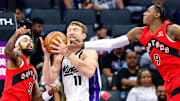 Sacramento Kings center Domantas Sabonis fights for a rebound against Toronto Raptors forwards Brandon Ingram and RJ Barrett