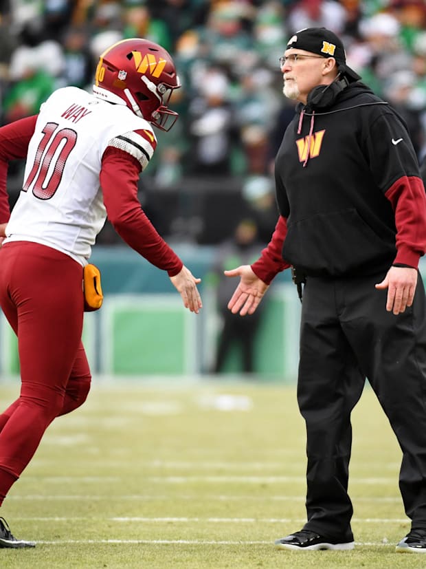 Washington Commanders punter Tress Way (10) high fives head coach Dan Quinn.