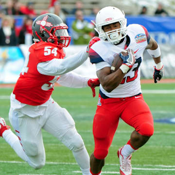 Dec 19, 2015; Albuquerque, NM, USA; Arizona Wildcats running back Jared Baker (23) dodges a tackle by New Mexico Lobos linebacker Donnie White (54) during a 27 yard touchdown run in the second half in the 2015 New Mexico Bowl at University Stadium. Mandatory Credit: Matt Kartozian-Imagn Images
