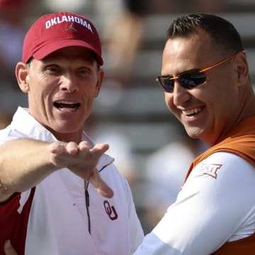 Oklahoma Sooners coach Brent Venables (left) speaks with Texas Longhorns coach Steve Sarkisian (right) before the game at the Cotton Bowl.