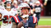 New England Patriots running back Treveyon Henderson runs for a touchdown past Tampa Bay Buccaneers cornerback Josh Hayes.