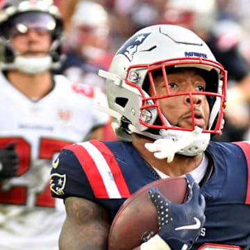 New England Patriots running back Treveyon Henderson runs for a touchdown past Tampa Bay Buccaneers cornerback Josh Hayes.