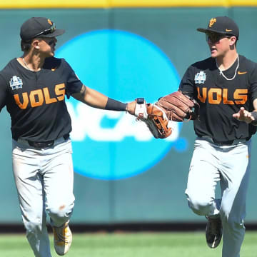 Tennessee's Hunter Ensley (9) and Tennessee's Dylan Dreiling (8) knock gloves after the third out to end the inning against Texas A&M in game two of the NCAA College World Series finals at Charles Schwab Field in Omaha, Neb., on Sunday, June 23, 2024.