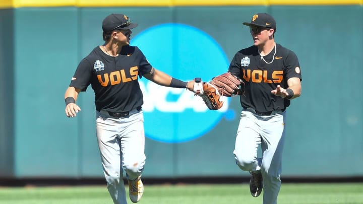 Tennessee's Hunter Ensley (9) and Tennessee's Dylan Dreiling (8) knock gloves after the third out to end the inning against Texas A&M in game two of the NCAA College World Series finals at Charles Schwab Field in Omaha, Neb., on Sunday, June 23, 2024.